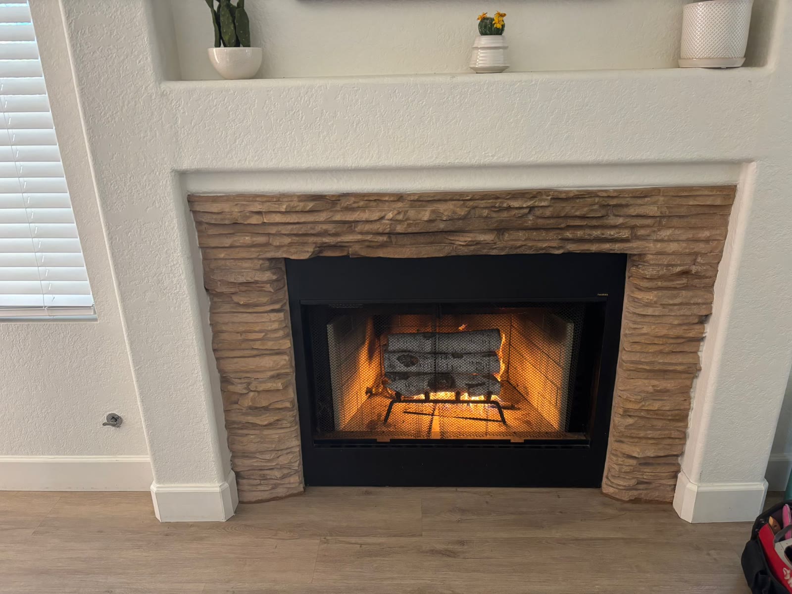 Finished gas fireplace conversion with stone surround and warm gas flames
