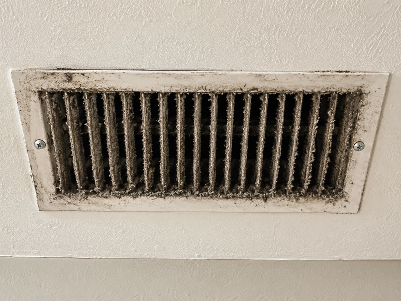 Before: dust-clogged air duct showing allergen and debris buildup